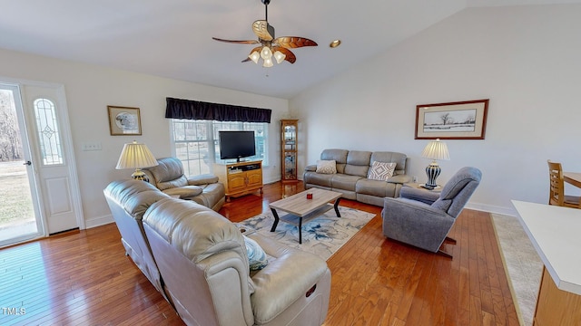 living room with wood-type flooring, vaulted ceiling, ceiling fan, and a healthy amount of sunlight