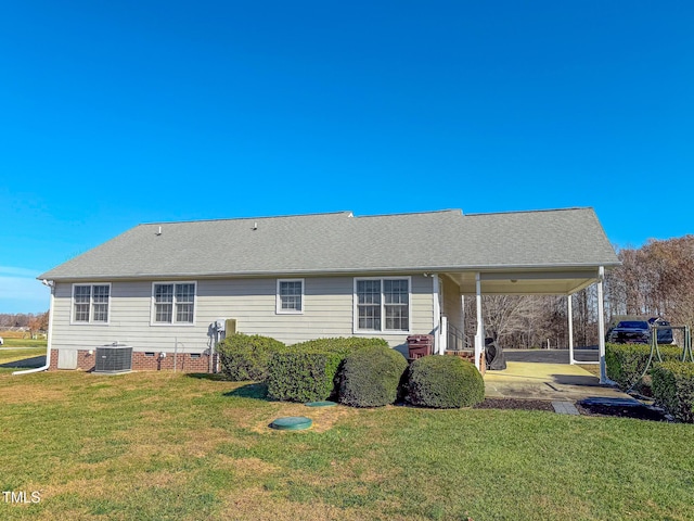 rear view of house featuring a lawn and central AC