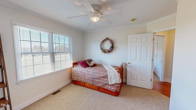 carpeted bedroom with ceiling fan and crown molding