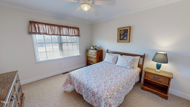 carpeted bedroom featuring ceiling fan and crown molding