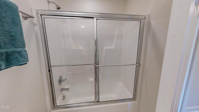 bathroom featuring combined bath / shower with glass door