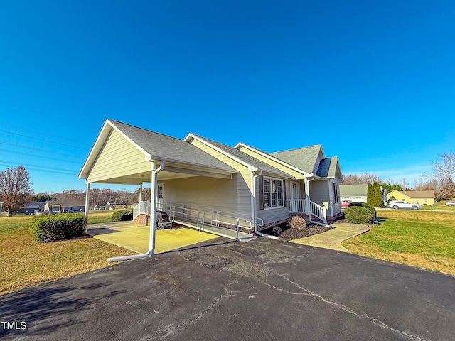 view of front facade with a carport and a front yard