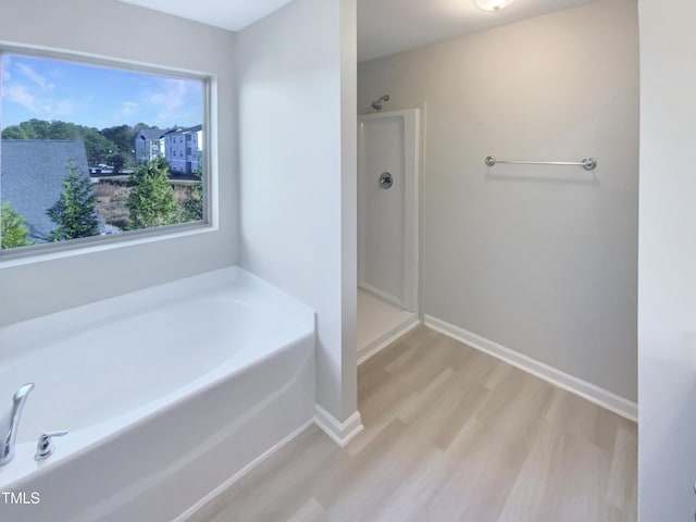 bathroom with separate shower and tub and hardwood / wood-style flooring