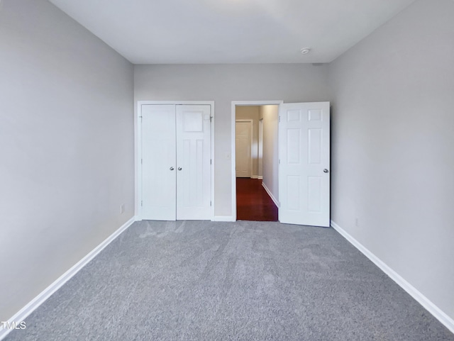 unfurnished bedroom featuring dark colored carpet and a closet