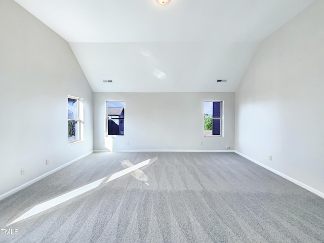 unfurnished room with light colored carpet and lofted ceiling