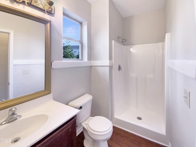 bathroom featuring a shower, toilet, vanity, and hardwood / wood-style flooring