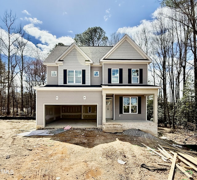 view of front of property with a porch, driveway, a shingled roof, and a garage