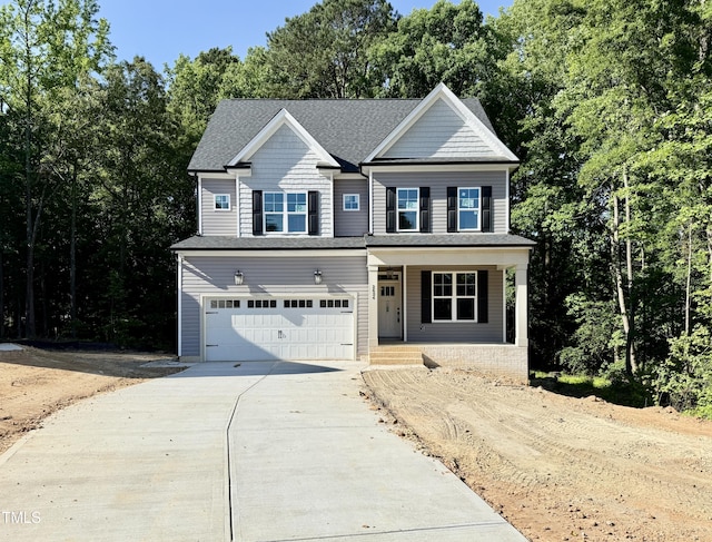 2624 Silver Gate Ct, Wake Forest, NC 27587 - view of front of property with driveway, a garage, covered porch, a shingled roof, and view of scattered trees