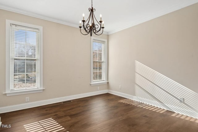 empty room featuring a wealth of natural light, crown molding, dark hardwood / wood-style floors, and a notable chandelier