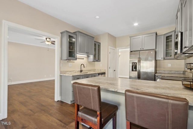 kitchen with gray cabinetry, stainless steel fridge, sink, and ceiling fan