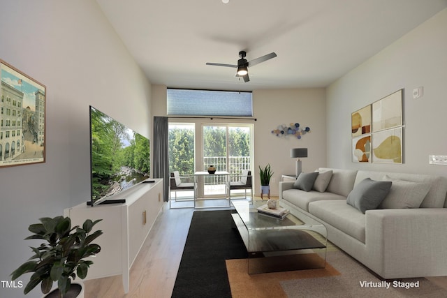 living room with ceiling fan and light hardwood / wood-style flooring