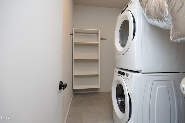 laundry area featuring stacked washing maching and dryer and light tile patterned flooring