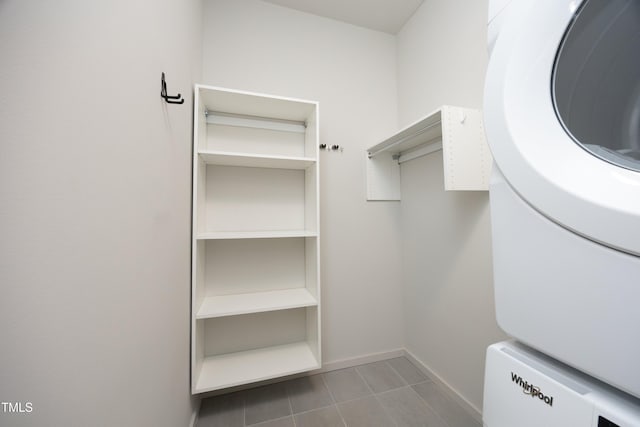 spacious closet with stacked washing maching and dryer and light tile patterned flooring