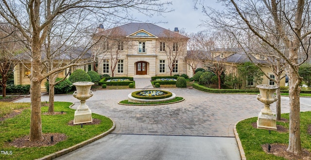 view of front of home featuring curved driveway and a chimney