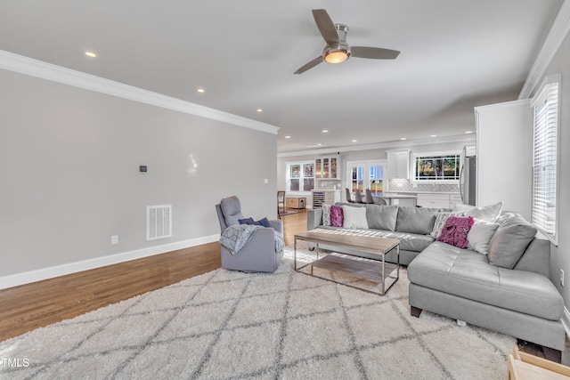 living room featuring ceiling fan, light hardwood / wood-style flooring, and ornamental molding