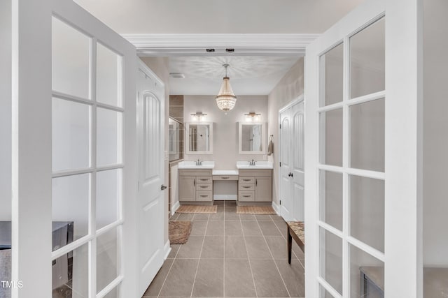 bathroom featuring tile patterned flooring, vanity, and an inviting chandelier