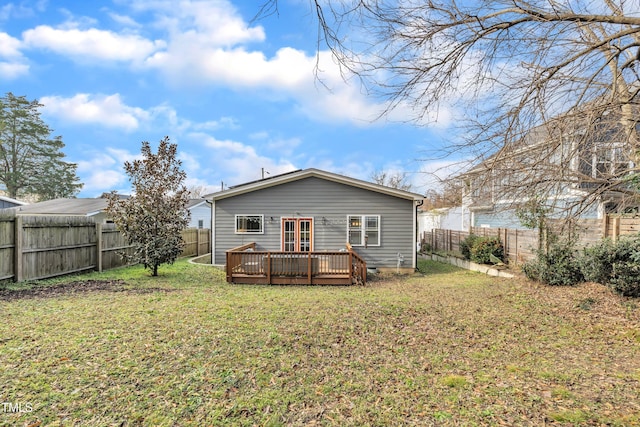 back of property featuring a deck and a lawn