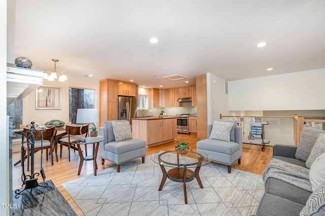 living room with an inviting chandelier and light hardwood / wood-style flooring