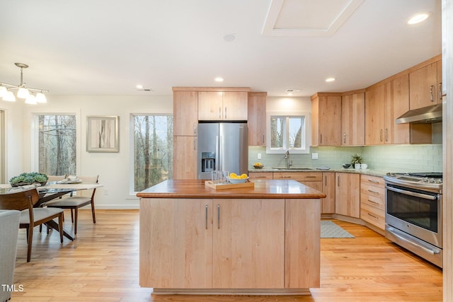 kitchen featuring a center island, sink, light hardwood / wood-style flooring, light brown cabinetry, and appliances with stainless steel finishes