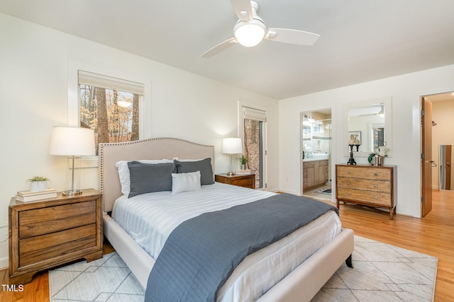 bedroom featuring connected bathroom, ceiling fan, and light wood-type flooring