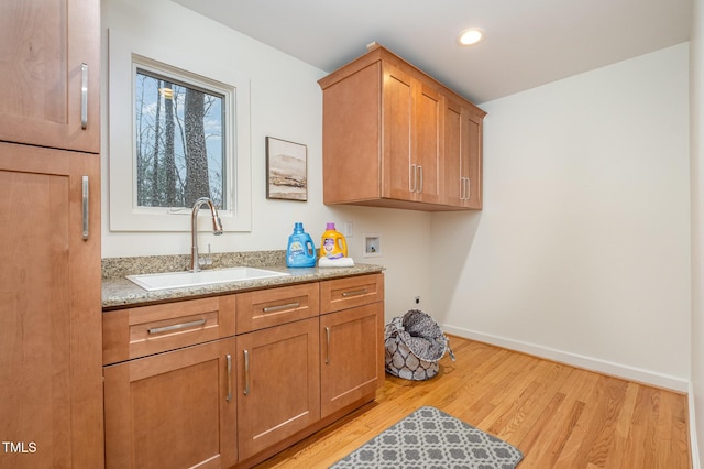 laundry area with cabinets, sink, hookup for a washing machine, light wood-type flooring, and hookup for an electric dryer