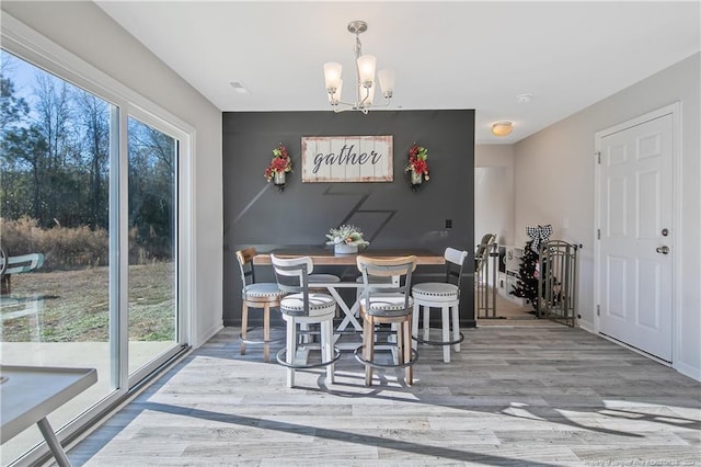 dining space featuring hardwood / wood-style flooring and a notable chandelier