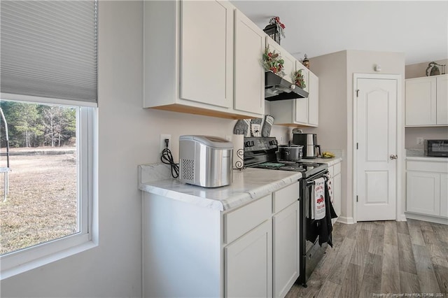 kitchen with black / electric stove, white cabinetry, plenty of natural light, and extractor fan