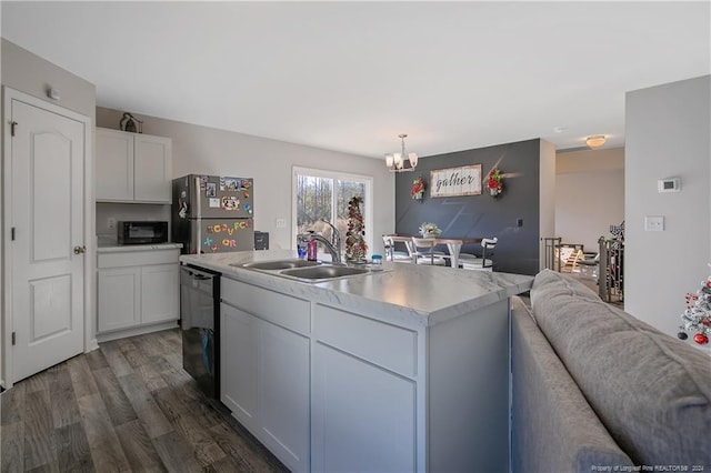 kitchen with black appliances, white cabinets, sink, hanging light fixtures, and an island with sink