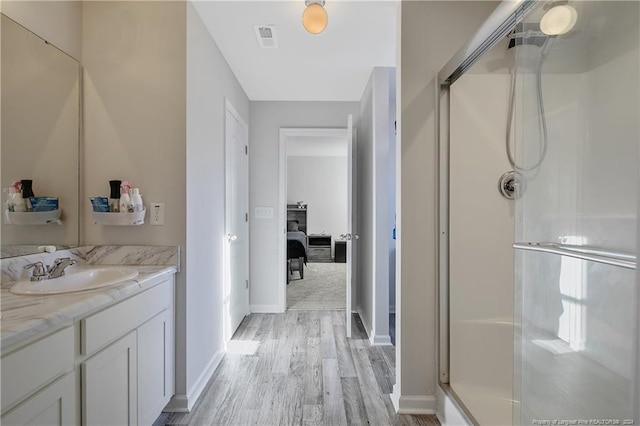 bathroom featuring vanity, an enclosed shower, and hardwood / wood-style flooring