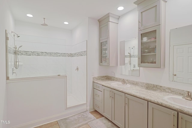 bathroom with a tile shower, tile patterned floors, and vanity