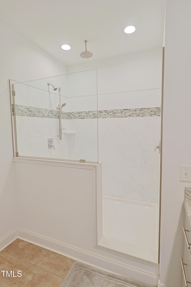 bathroom featuring tiled shower and tile patterned flooring