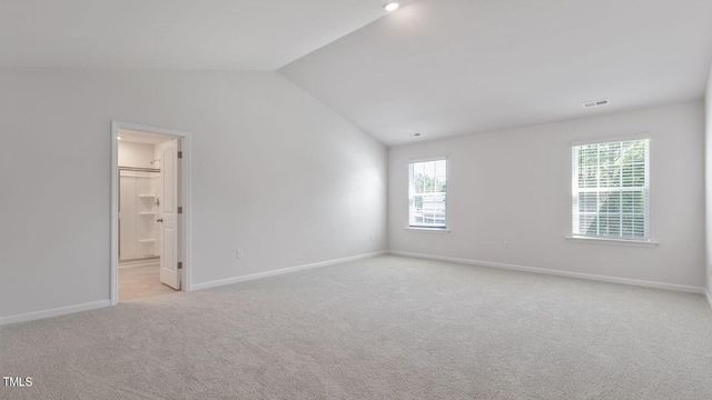 carpeted spare room with lofted ceiling