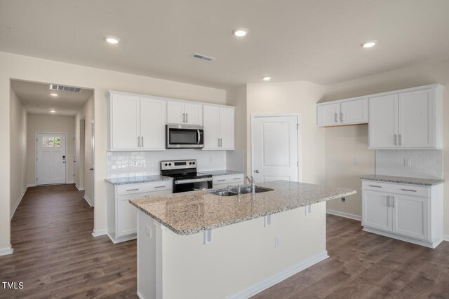 kitchen with white cabinets, appliances with stainless steel finishes, and a center island with sink