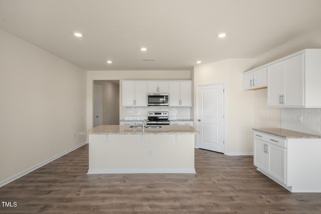 kitchen with white cabinetry, a kitchen island with sink, dark hardwood / wood-style flooring, and stainless steel appliances