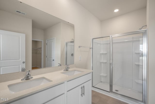 bathroom with vanity and a shower with door