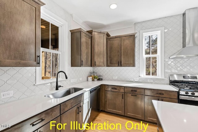 kitchen featuring sink, wall chimney range hood, backsplash, light hardwood / wood-style floors, and appliances with stainless steel finishes