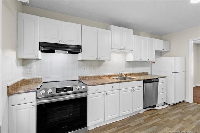 kitchen with appliances with stainless steel finishes, tasteful backsplash, sink, light hardwood / wood-style floors, and white cabinetry