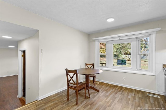 dining space featuring a textured ceiling and light wood-type flooring