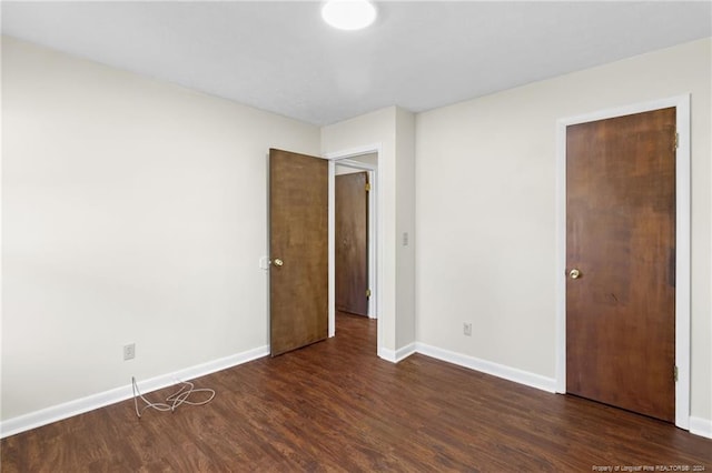 unfurnished bedroom featuring dark hardwood / wood-style flooring and a closet