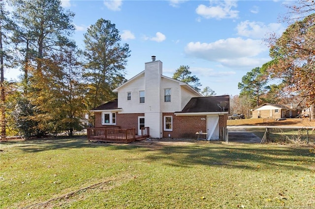 rear view of house with a deck and a lawn