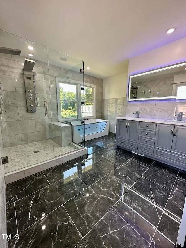 bathroom with vanity, independent shower and bath, and tile walls