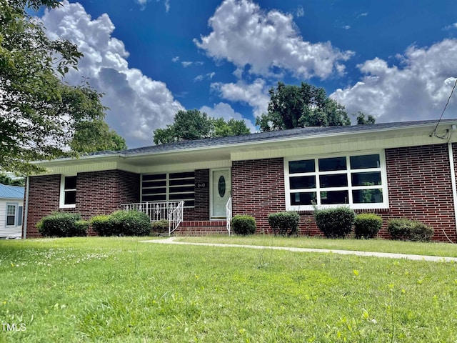 single story home with a front lawn and covered porch