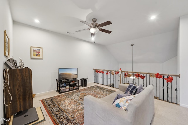 carpeted living room with ceiling fan and vaulted ceiling