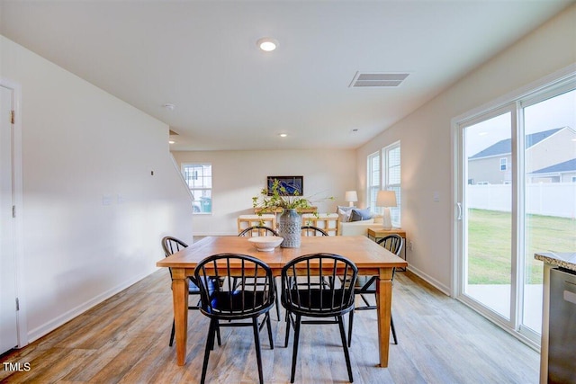 dining area featuring light wood-type flooring and plenty of natural light