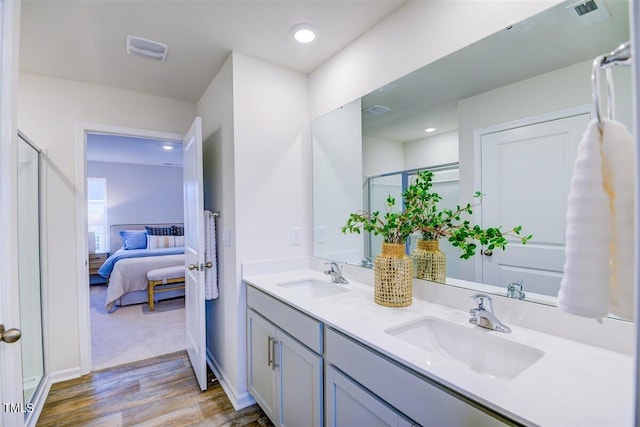 bathroom featuring vanity, hardwood / wood-style flooring, and a shower with door