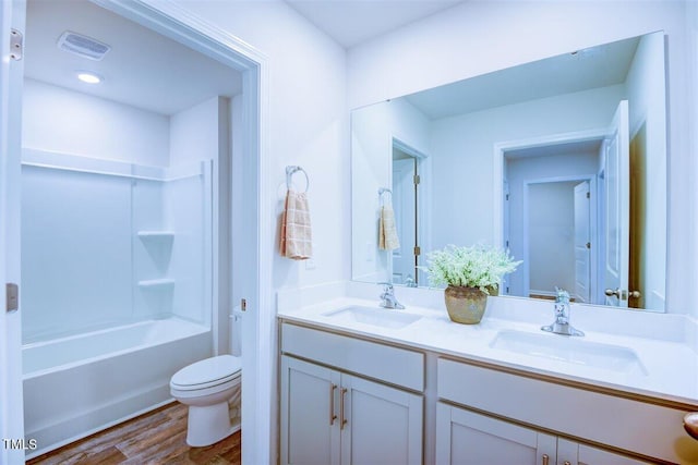 full bathroom with shower / bathing tub combination, hardwood / wood-style floors, vanity, and toilet