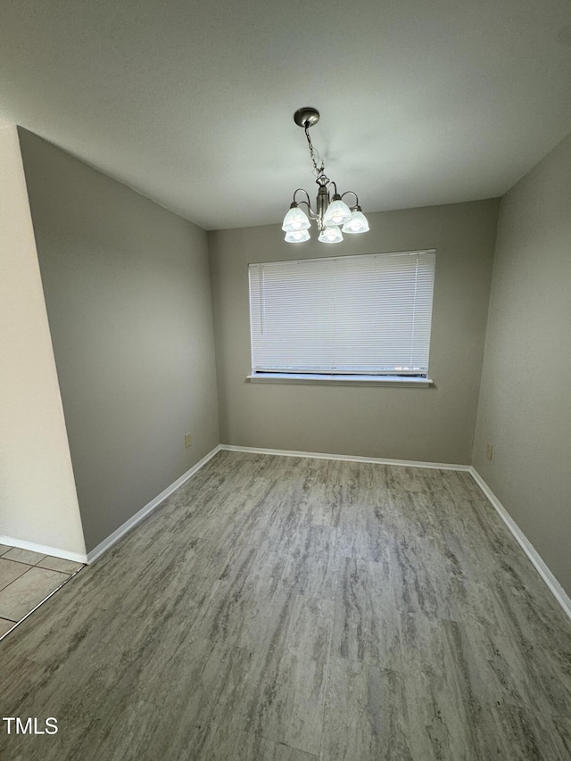 unfurnished dining area with a chandelier and light wood-type flooring