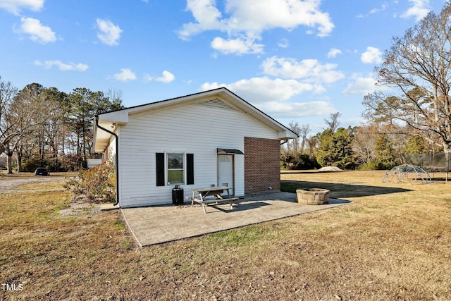 back of house featuring a lawn and a patio