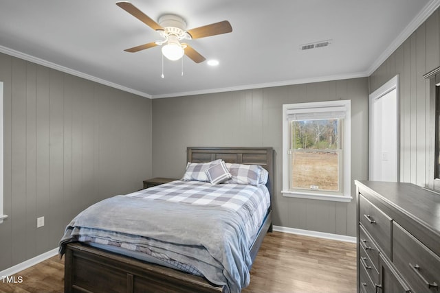 bedroom with light hardwood / wood-style floors, ceiling fan, and ornamental molding