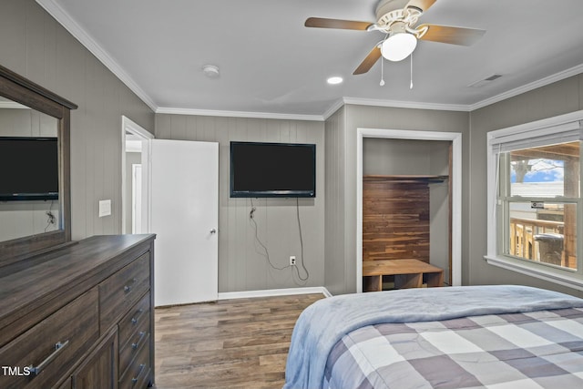 bedroom featuring crown molding, a closet, ceiling fan, and hardwood / wood-style flooring